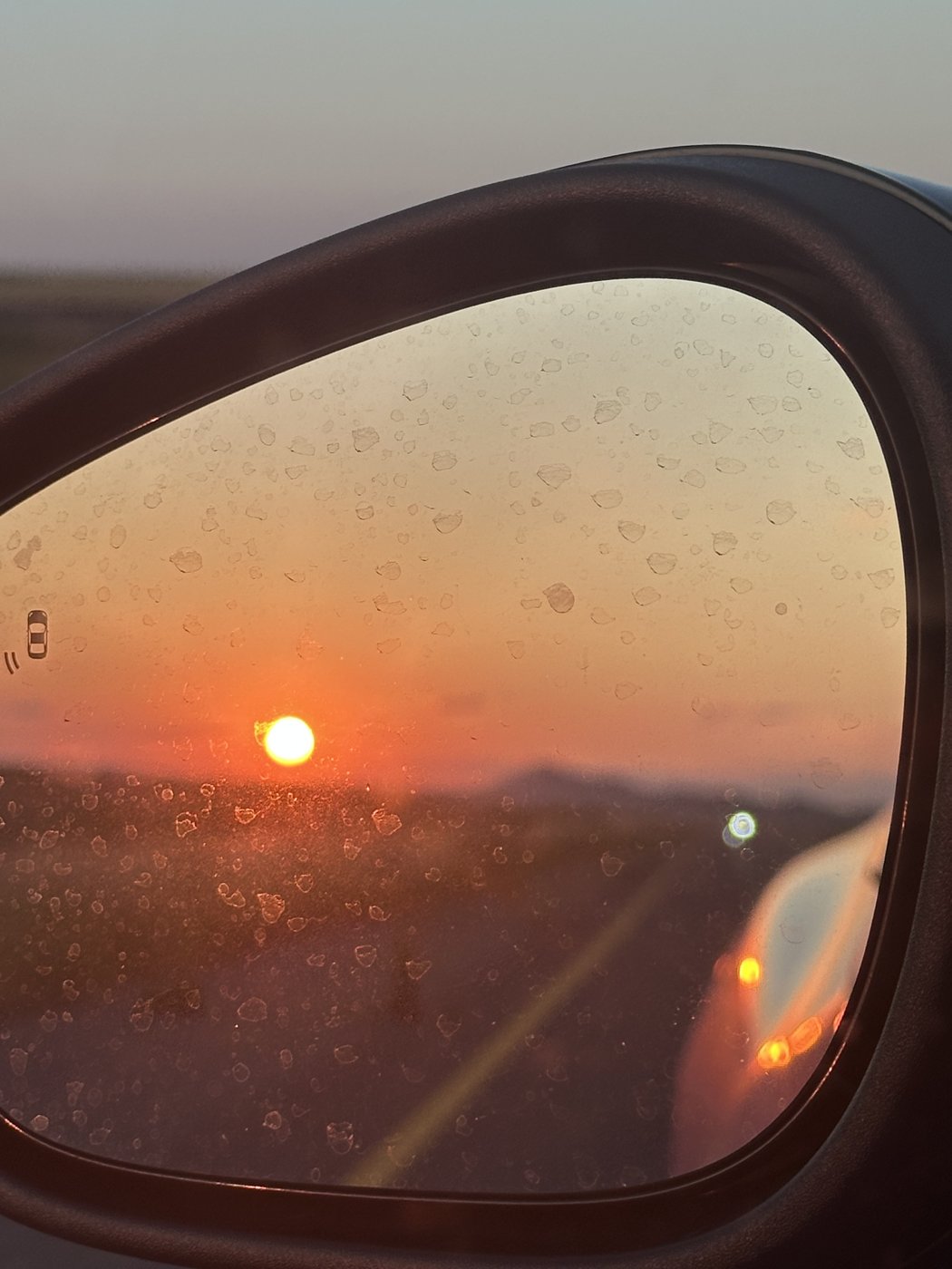 Sunset reflected in a car's side mirror